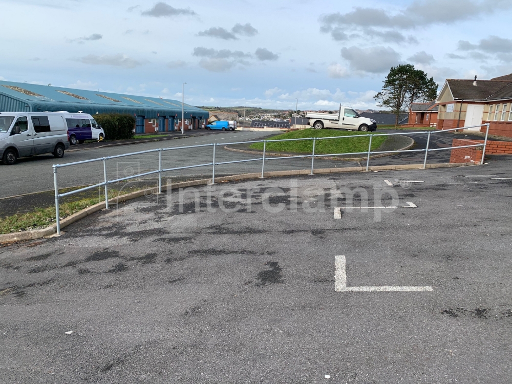 Industrial car park featuring a guardrail made from Interclamp key clamp fittings and tube, offering enhanced safety and durability.